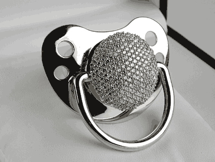 A pacifier, made of white gold, with diamonds.